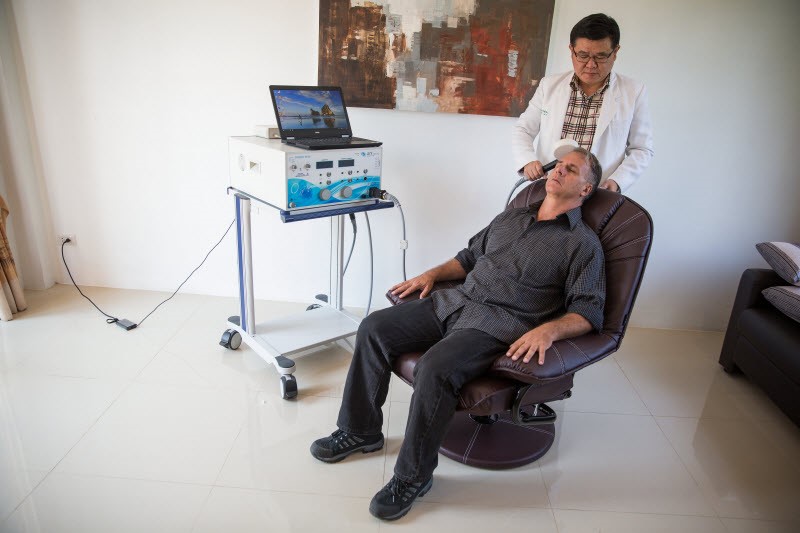 Dr Ngamwong administers TMS therapy to a client at The Dawn