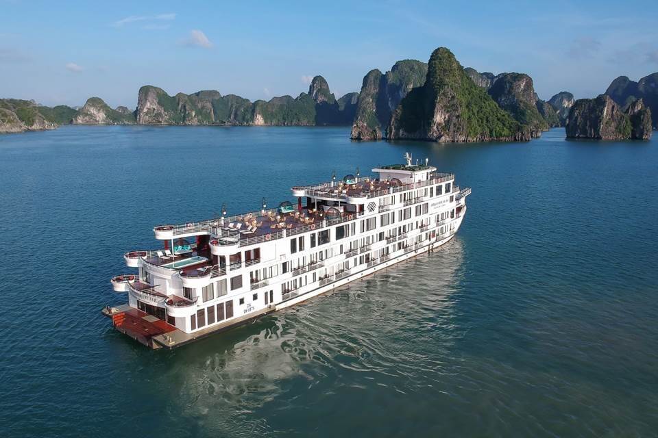 On the first day of the cruise, passengers board Ambassador Cruise 1, the largest and most luxurious vessel in Halong Bay, featuring 46 cabins with a private balcony or terrace, twin 360-degree sundecks, a restaurant, plush piano lounge, bars, an open-air Jacuzzi pool, and a spa.