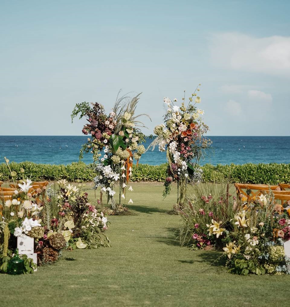 Sweeteners for the bride and groom include a live guitarist and violinist during the ceremony, all sorts of exquisite flower arrangements, and a three-tier wedding cake.