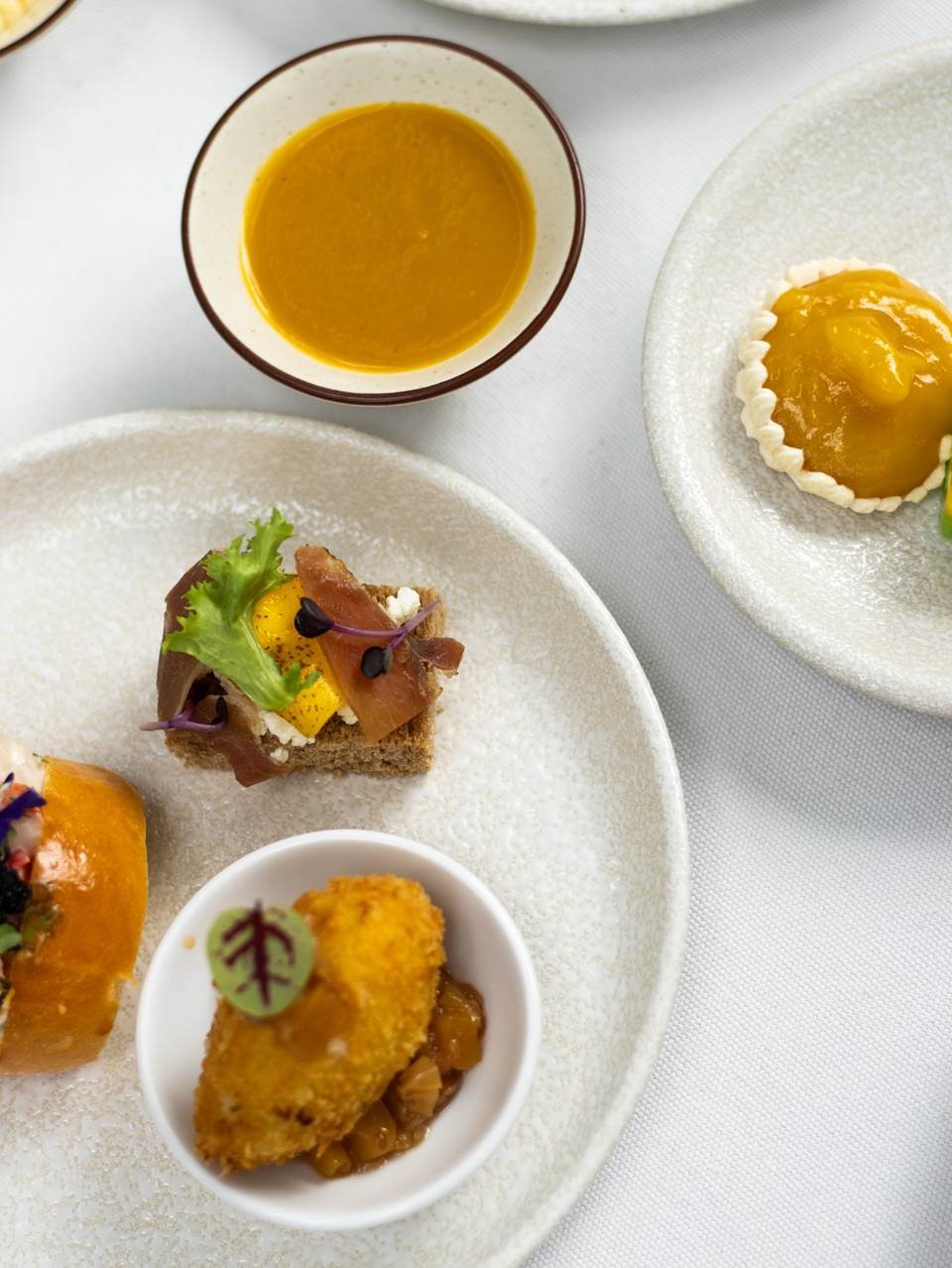 Poached tiger prawns with mango salsa, tobiko and brioche roll, Iberico Bellota slice with charred mango and whole grain mustard dressing served with sourdough toast, and salmon croquettes with crème fraîche and mango chutney are among the afternoon tea’s savouries.